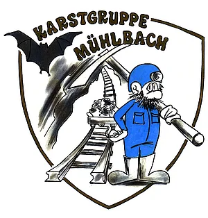 Zeichnung in Wappenform, darauf Höhlenforscher mit Pickel vor Gleisanlage, darüber Schriftzug "Karstgruppe Mühlbach"