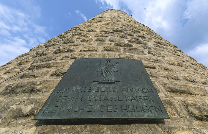 Bronzetafel an einem steinernen Turm mit der Inschrift zur Geburt von Kaiser Heinrich II. am 6. Mai 973 in Bad Abbach.