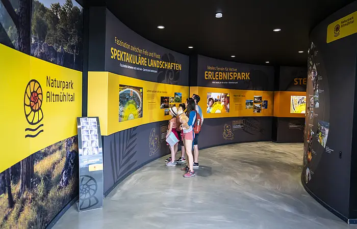 Eine Familie erforscht die Naturpark Altmühltal Ausstellung im Dinopark Denkendorf.