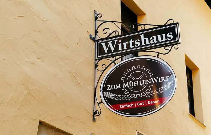 Wirtshausschild mit dem Namen Wirtshaus zum Mühlenwirt