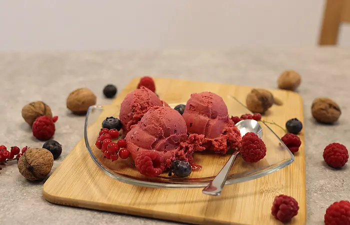 Eiskugeln drapiert auf Glasteller mit Früchten dekoriert