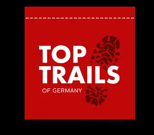 Das Logo besteht aus einem schwarzem Schuhabdruck und in weiß steht TopTrails of Germany auf rotem Hintergrund.