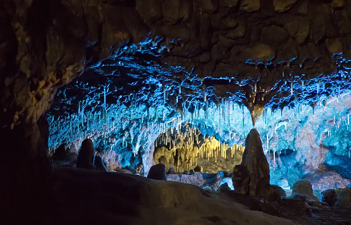 Die Tropfsteinhöhle mit ihren Stalagniten blau ausbeleuchtet.