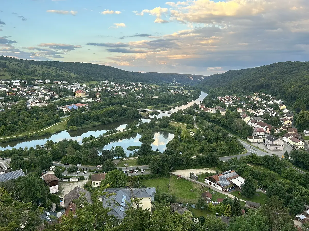 Wir schauen auf Riedenburg hinunter und können den Kanal sowie viel Wald erkennen. Der Himmel ist schon etwas dämmerig.