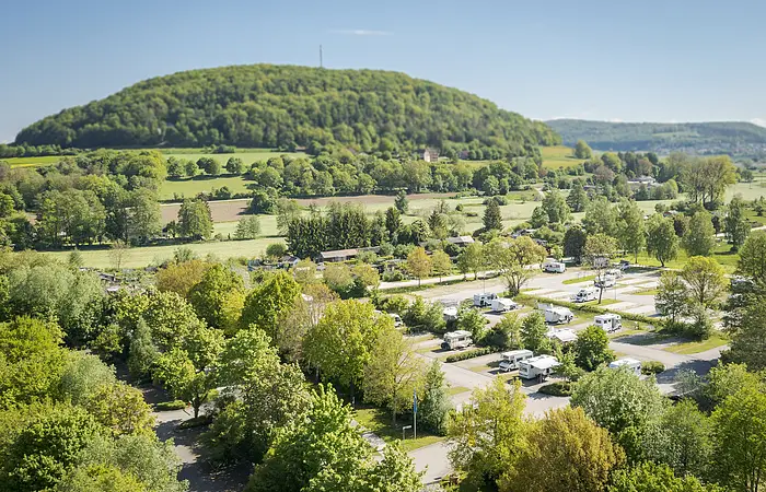 Luftaufnahme vom Reisemobilstellplatz im Hintergrund drohnt der Nagelberg