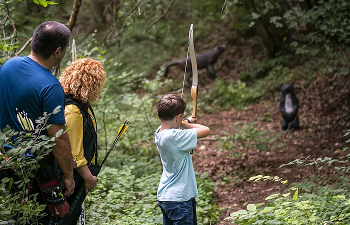 Eine Familie ist am 3D-Bogenschieß-Parcour unterwegs.