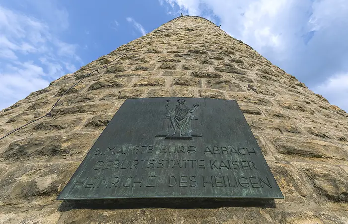 Bronzetafel an einem steinernen Turm mit der Inschrift zur Geburt von Kaiser Heinrich II. am 6. Mai 973 in Bad Abbach.