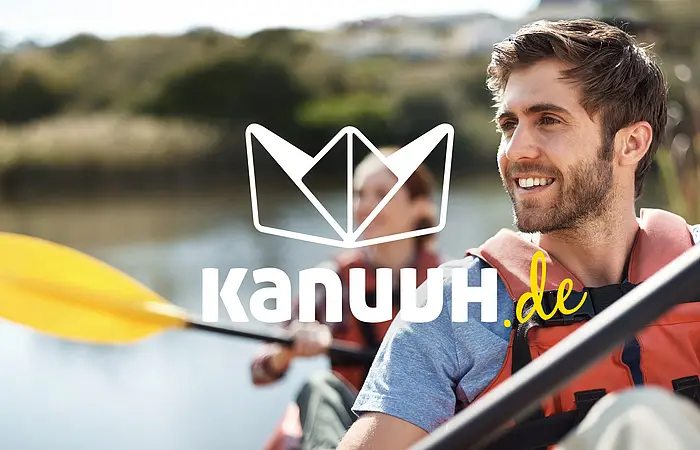 Zwei Paddler, ein Mann vorne und eine Frau mit gelben Paddel, deren Gesicht vom Logo einem Papierschiffchen verdeckt wird.