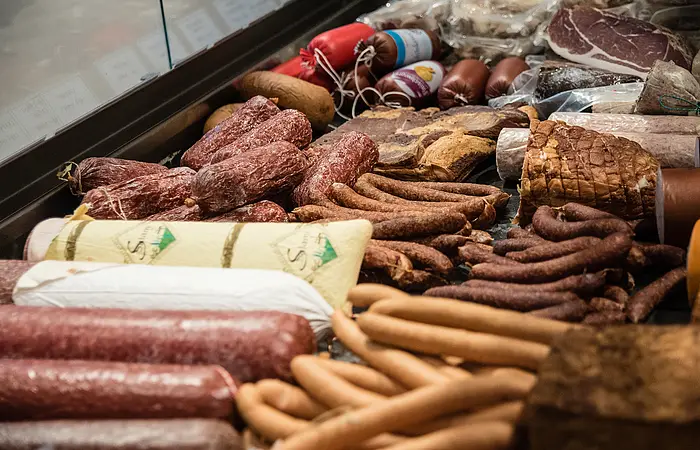 Eine reichlich gefüllte Wursttheke ist zu sehen.