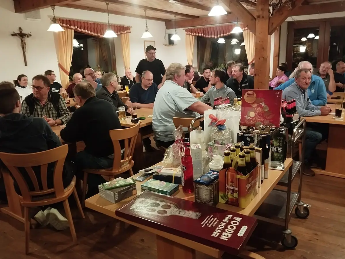 Viele Menschen im Gastraum im Gasthaus zur Krone. Im Vordergrund ein Geschenketisch für die Preisverleihung.