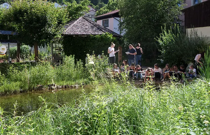 Schulklasse am Teich im Biotopgarten