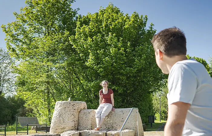 Pärchen sitzt am Tretbecken und geniest die Umgebung.