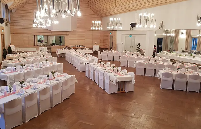 Von oben fotografiert sieht man den kleinen und großen Saal. Die Bestuhlung ist sternförmig angeordnet, das Kalt-Warme Buffet wird im kleinen Saal aufgebaut. Die Trennwand wurde zurückgefahren, damit beide Räume einen großen Saal bilden.