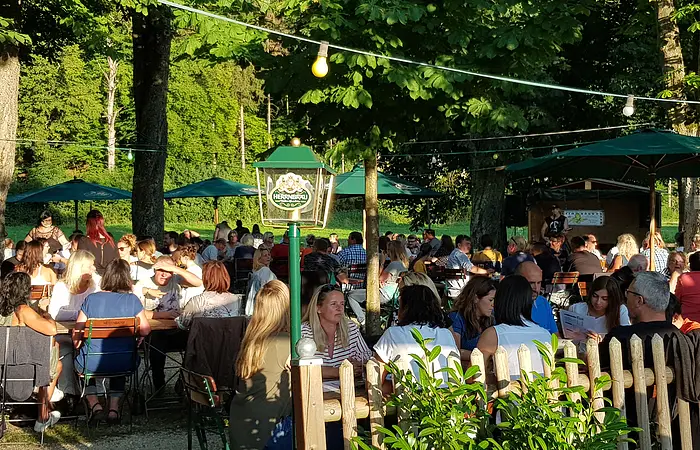 Blick in den Biergarten an der Stadthalle direkt am Altmühlufer an einem sonnigen Sommertag.