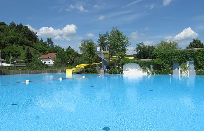 Schwimmbecken mit Rutsche im Hintergrund