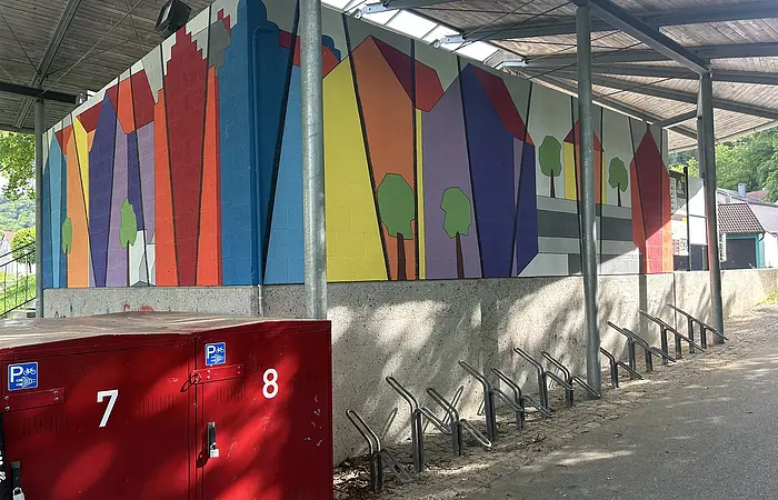 Die roten, nummerierten Fahrradboxen stehen unter dem Dach direkt am Großparkplatz inmitten Riedenburgs.