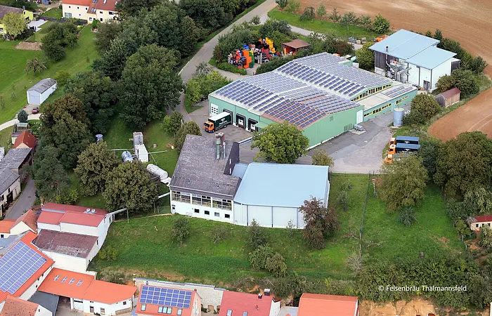 Luftbild eines Brauereigeländes. Große Lagerhalle mit Solarpanele auf dem Dach.