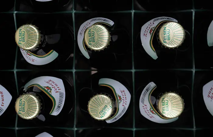 Kiste mit zwölf Felsenbräu-Bierflaschen, Draufsicht auf die Kronkorken.