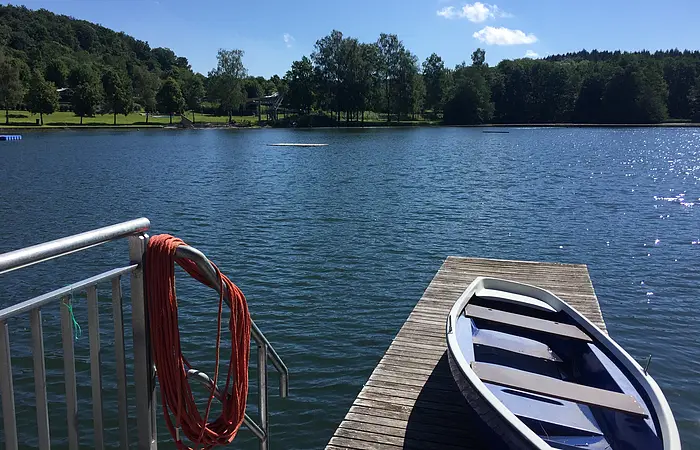 Ein Ruderboot auf dem Steg am Waldsee