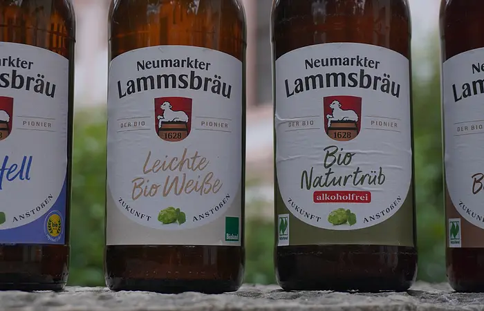Vier Bierflaschen der Marke Neumarkter Lammsbräu mit verschiedenen Biersortenetiketten.