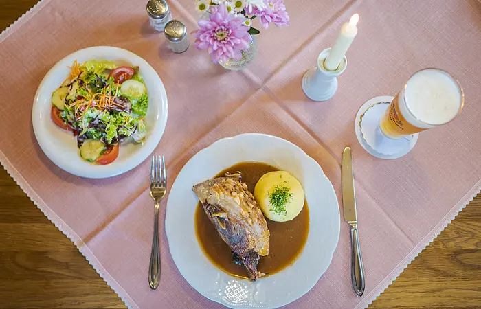 Gaststube, gedeckter Tisch von oben fotografiert mit Schäufele, Kloß, Salat und Weizen