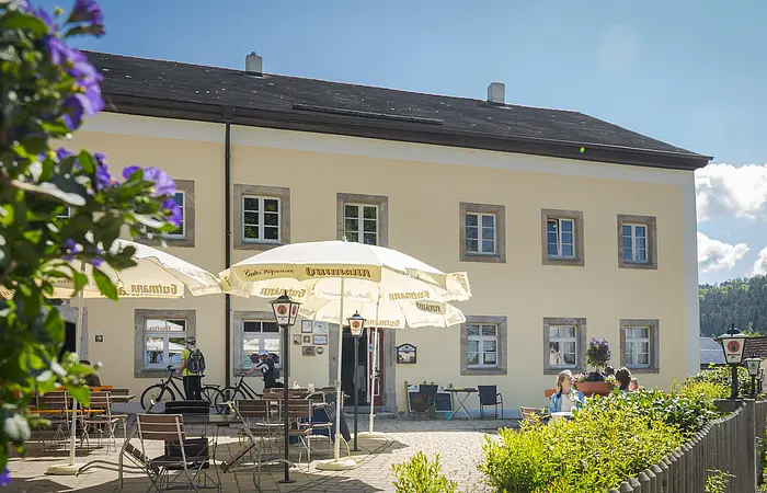 Aussenansicht mit Biergarten und Sonnenschirmen