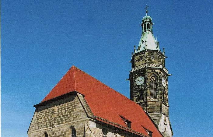 Rückansicht auf die Evangelische Stadtpfarrkirche in Roth mit dem Glockenturm mit romantischen Elementen.