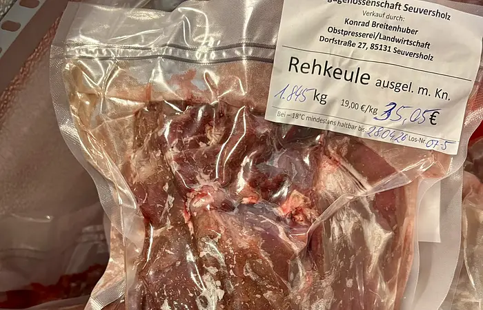 Vakuumverpacktes Rehkeulenfleisch mit Etikett und Preisangabe in einer Kühltruhe.