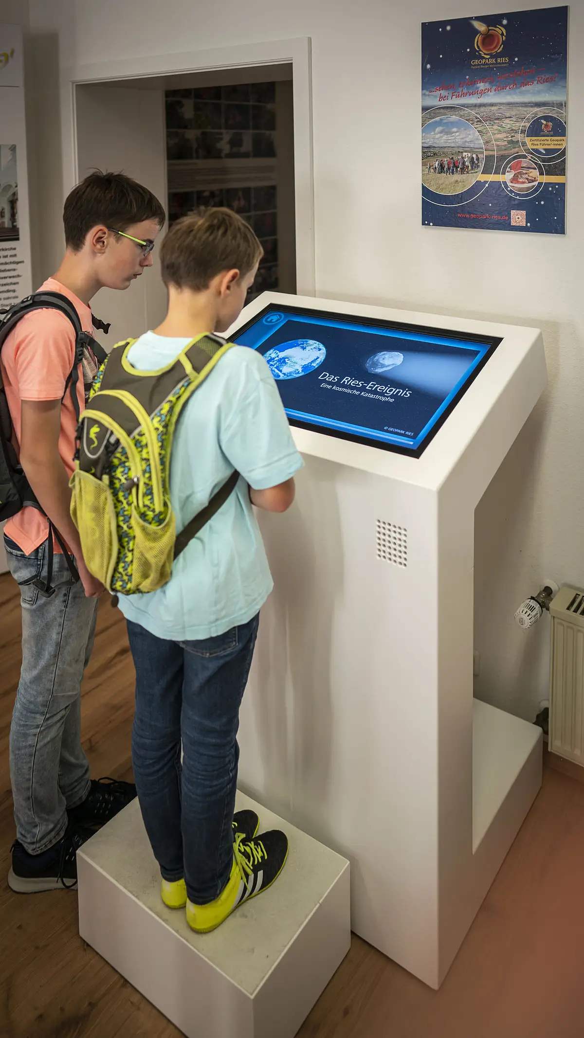 Kinder schauen sich die Ries-Animation in der Geopark-Infostelle an.