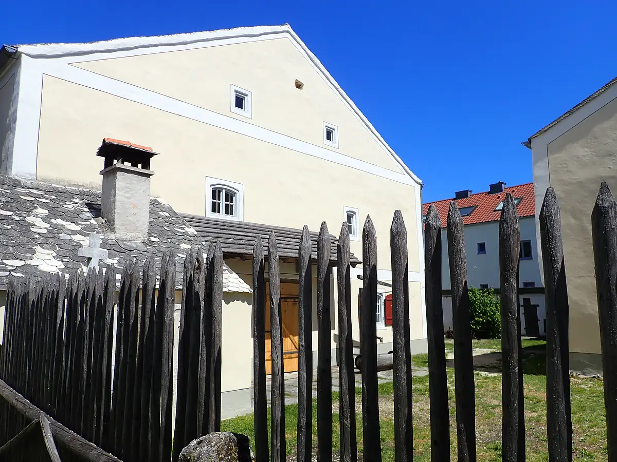 Jura-Bauernhof-Museum vom Garten aus Blick von hinten auf das Hauptgebäude mit dem kalkgedeckten Holzbackofen am linken Bildrand.