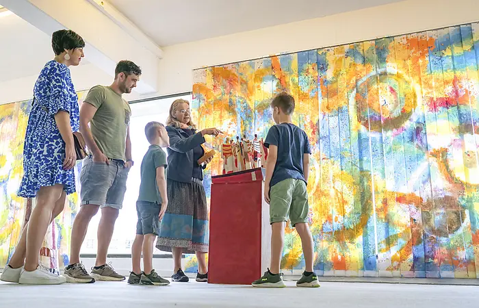 Eine Familie sieht sich im KunstMuseum ein Kunstwerk an.