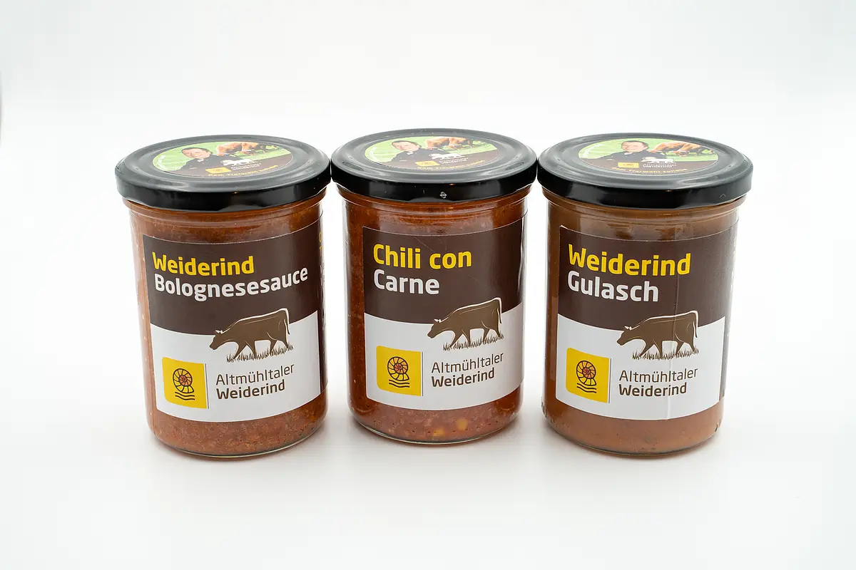 Produkte des Altmühltaler Weiderind Drei Gläser mit Weiderind Bolognesesauce, Chili con Carne und Weiderind Gulasch vor weißem Hintergrund.
