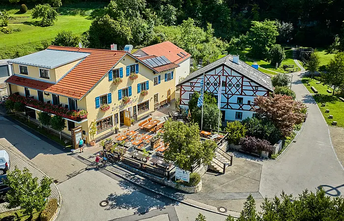 Der Gasthof mit seinen Gebäuden von oben ist zu sehen. Im Hintergrund ist fängt schon der Wald an.