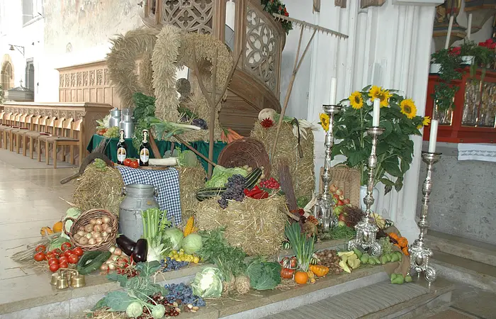 Die Erntedankdekoration mit zur Krone gebundenem Getreide und verschiedenem Obst und Gemüse.