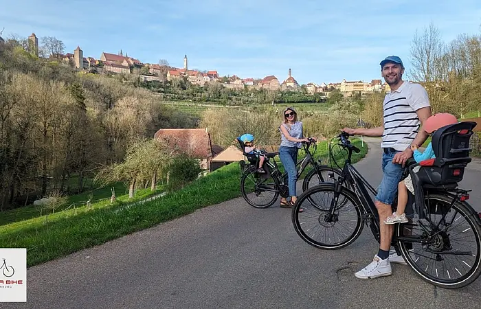 Eine Familie mit den ausgeliehenen Räder und Kindersitzen der Firma rent a bike unterwegs in Rothenburg o. d. Tauber