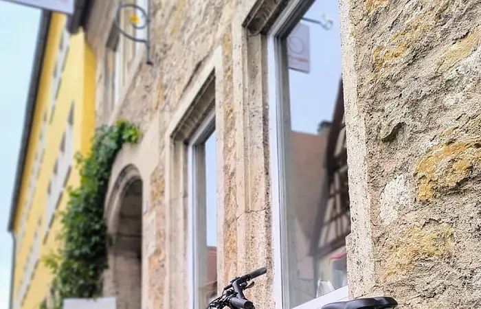 Ein rotes Fahrrad steht vor dem Laden in der Stadt Rothenburg o. d. Tauber.