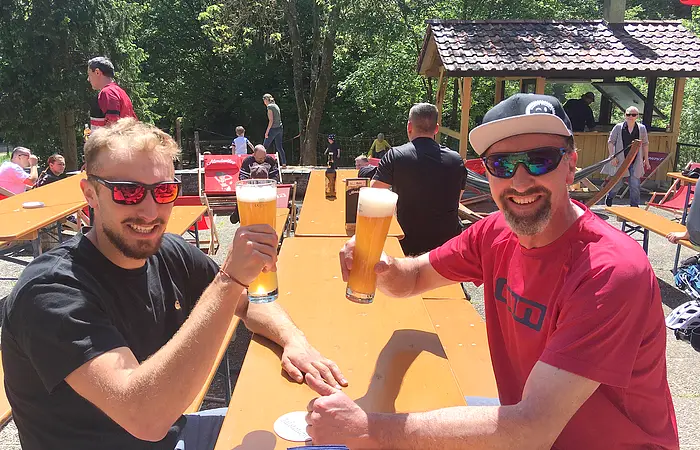 Zwei Herren prosten sich zu auf der Sonnenterrasse der Talstation Heumöderntal