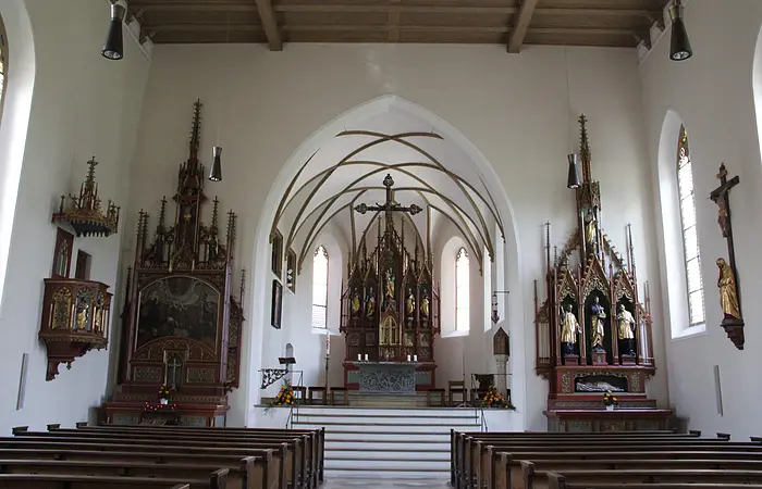 Blick auf das schlichte Innere von St. Sebastian. Vorne in der Mitte der Hauptaltar. Rechts und links im Bild die beiden Seitenaltäre sowie ganz vorne links im Bild die Kanzel.