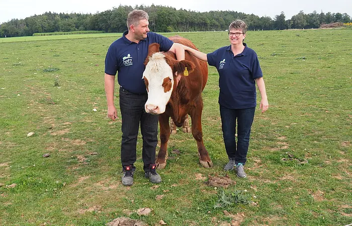 Herr und Frau Betz mit zahmen Ochsen auf Wiese