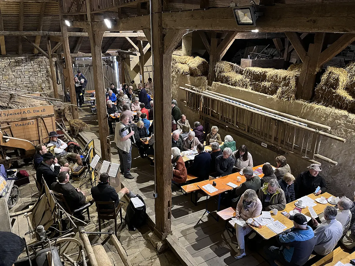 Kirchweih im Stadel des JBM Musiker, Ernst Schusser und Publikum in der Tenne des Jura-Bauernhif-Museums