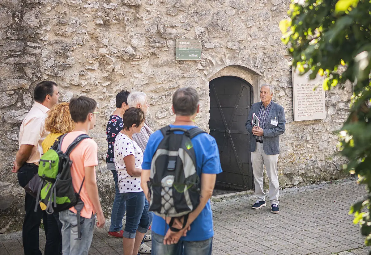 Stadtführung am Folterturm Ein Stadtführer stellt den Folterturm während einer Stadtführung einer Gruppe vor.